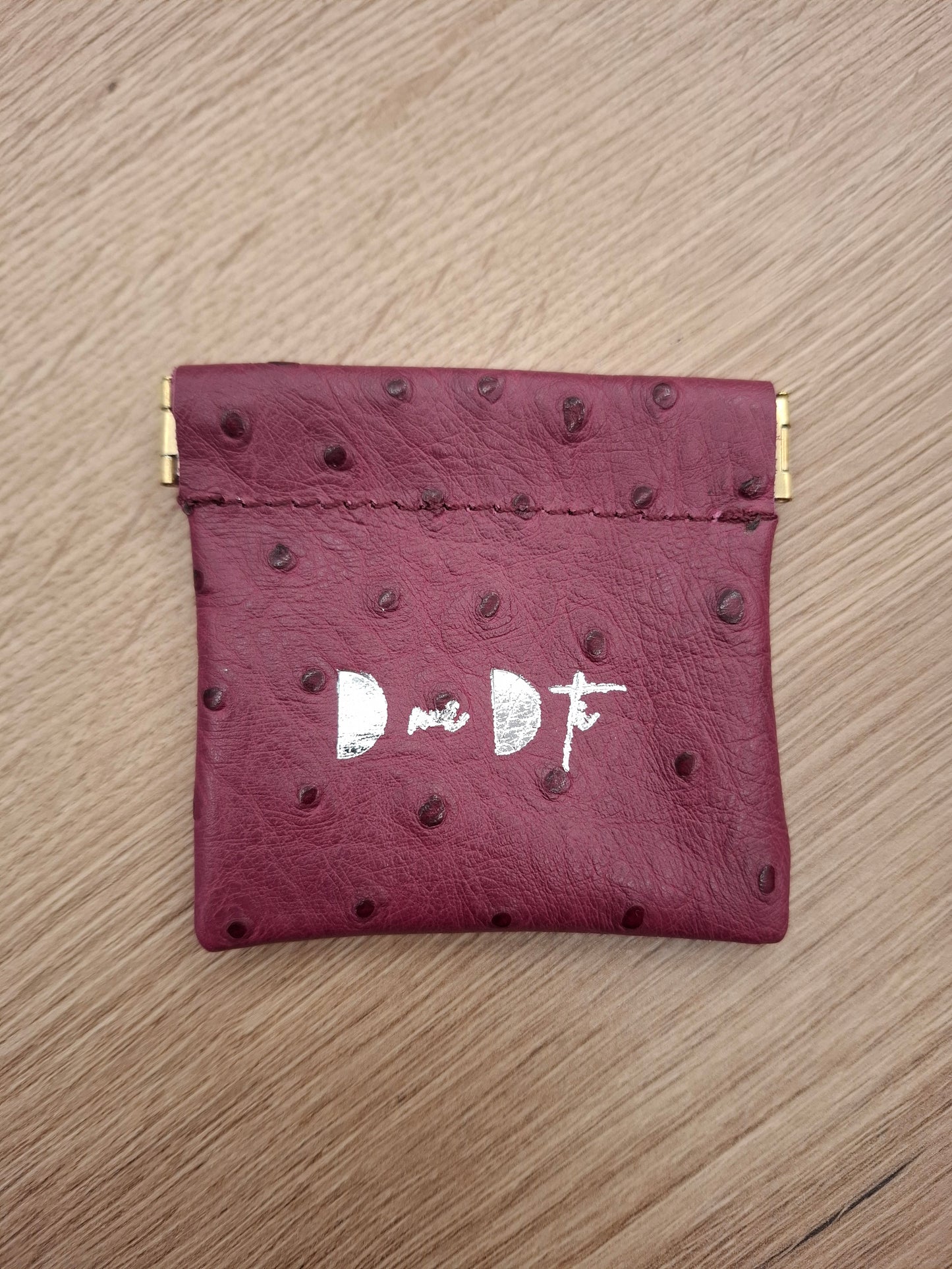 Monedero fleje piel berenjena estampado avestruz